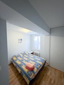 a small bedroom with a bed with a colorful blanket at Maison 3 chambres, Agen centre, climatisé, 6 personnes in Agen