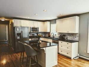 a kitchen with white cabinets and black counter tops at Bar Harbor Island Escape in Bar Harbor
