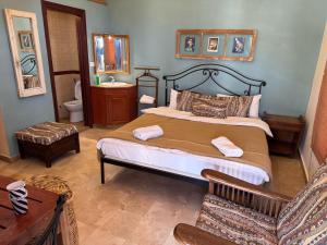 a bedroom with a bed and a chair in it at Soha Village Resort in Fālūghā