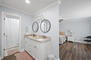 a bathroom with a sink and two mirrors on a wall at Peaceful Fairhope Retreat-Large home on 1 acre lot in Fairhope +25 photos