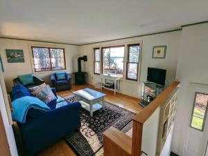 a living room with a blue couch and a tv at Tideside Beach House in Trenton