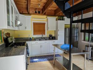 a kitchen with white cabinets and a wooden ceiling at Acadia Park Suites Condo in Southwest Harbor