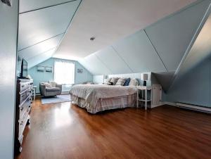 una camera da letto con un letto e una sedia in una stanza di NEW Beachy Watering Cove Cottage a Prospect Harbor