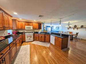 a large kitchen with wooden cabinets and a table at Acadia Luxury Penthouse Suite in Trenton