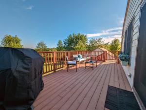 a deck with two chairs and a table on it at Acadia Luxury Penthouse Suite in Trenton