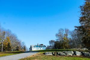a white house on the side of a road at Bayside Waterview Cottage in Ellsworth