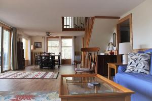 a living room with a blue couch and a table at Somes Pond Island Cottage in Southwest Harbor