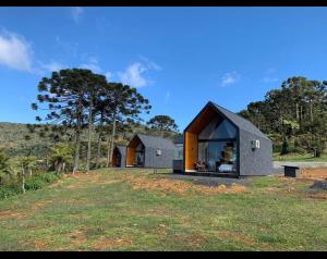 a house on a grassy hill with trees in the background at Refúgio da Realeza in Urubici +22 photos