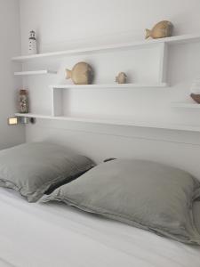 a bed with white shelves and a pillow at Le B - A 200 m de la plage in Arcachon