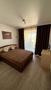 a bedroom with a bed and a large window at Deterra Studio 70 next to Metro Station Berceni in Popeşti-Leordeni