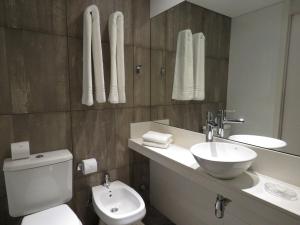 a bathroom with a toilet and a sink and a mirror at Smart Hotel Montevideo in Montevideo +37 photos