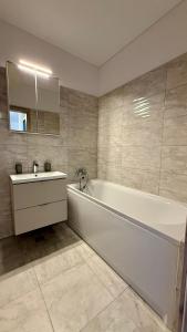 a white bathroom with a tub and a sink at Deterra Studio 70 next to Metro Station Berceni in Popeşti-Leordeni +12 photos