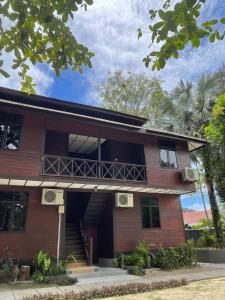 ein rotes Gebäude mit einem Balkon auf der Seite in der Unterkunft Arwana Beach Resort - BS in Pulau Perhentian Besar
