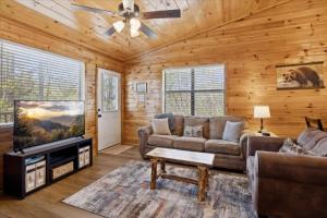a living room with a couch and a flat screen tv at A Dream Romance Cabin With Hot Tub & Fireplace in Sevierville