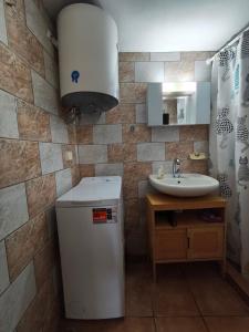 a bathroom with a sink and a small refrigerator at Traditional Stone House in Mantamádos +15 photos