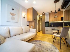 a living room with a white couch and a kitchen at Wrocławska 1 - Centrum in Żary