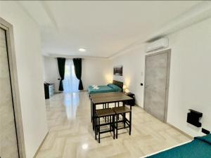 a living room with a table and a bed in a room at Green Home in Bari