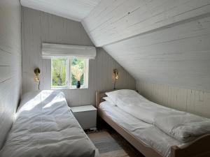 two beds in a small room with a window at Flo Lake House in Stryn