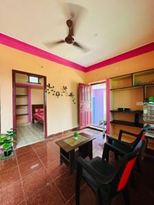 ティルヴァンナーマライにあるMURUGA Homestayのテーブルと椅子のあるリビングルーム