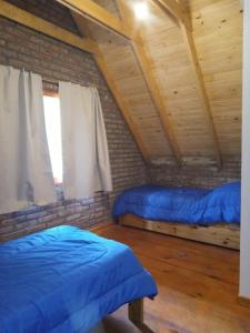 een kamer met twee bedden en een raam bij La Rubina in Villa Ventana +8 foto's