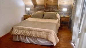 een slaapkamer met een bed met twee nachtkastjes en twee lampen bij La Rubina in Villa Ventana