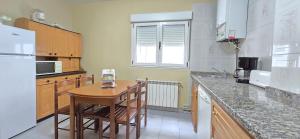 a kitchen with a wooden table and a counter top at Casa Pilar, Ribadesella in Ribadesella +9 photos