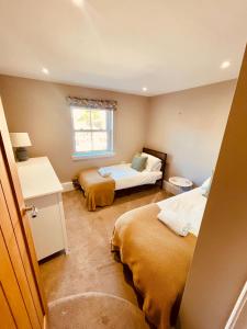 a bedroom with two beds and a window at Nomi Homes - New - The Coffers - Budleigh Salterton - Exmouth - Beach - Sleeps 4 in Exeter