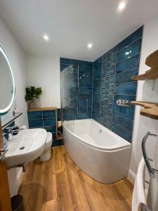 a bathroom with a tub and a toilet and a sink at Nomi Homes - New - The Coffers - Budleigh Salterton - Exmouth - Beach - Sleeps 4 in Exeter +15 photos
