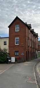 a large red brick building with windows on a street at Nomi Homes - New - The Coffers - Budleigh Salterton - Exmouth - Beach - Sleeps 4 in Exeter