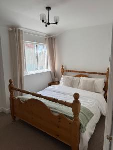 a bedroom with a wooden bed and a window at Valletta House Holiday Apartments in Skegness