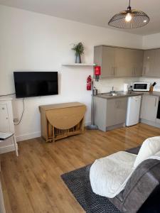 a living room with a kitchen and a room with a table at Valletta House Holiday Apartments in Skegness
