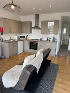 a living room with a couch in the middle of a kitchen at Valletta House Holiday Apartments in Skegness