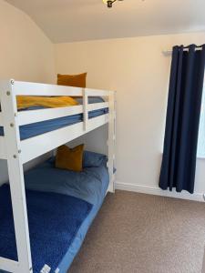a bedroom with a bunk bed with blue pillows at Valletta House Holiday Apartments in Skegness