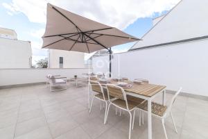 a patio with a table and chairs and an umbrella at Villa Perla de Pilar - Private pool and rooftop near Beach - by Oyoostays in Pilar de la Horadada