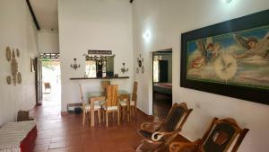 a living room with a table and a painting on the wall at Finca Hotel Auraviva in Ciénaga de Oro