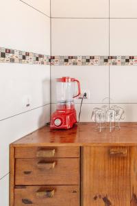 einem roten Mixer auf einer Holztheke in der Unterkunft Chalé Completo Com Linda Vista para o Mar de Ilhabela in Ilhabela