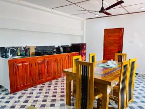 a kitchen with a wooden dining room table and chairs at Prasath guest house in Jaffna