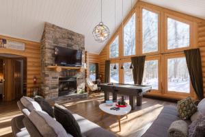 a living room with a piano and a fireplace at Relaxing Sauna and Hot Tub, Near Ski Slopes,Trails in Mille-Isles