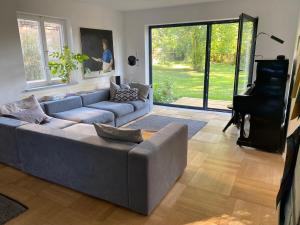 a living room with a couch and a piano at Künstlerhaus im Blauen Land für die grosse Familie in Ohlstadt