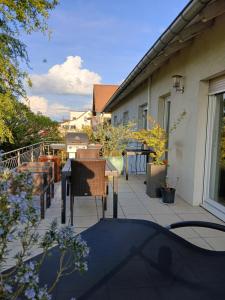 a patio with two chairs and a table on a house at Appartement entier LEA avec petit déjeuner in Hilsprich