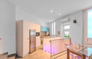 a kitchen with a stainless steel refrigerator and a table at Maison 4 chambres - Cannes centre -Clim WIFI 7 personnes in Cannes