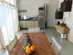 a kitchen with a wooden table with a bowl of fruit at Boadream Ca' Madeira 1 Attico Linea Prestige in Sal Rei +7 photos