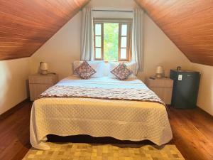 a bedroom with a large bed with a window at Chalés e Pousada - Casarão Histórico by Pousada Princesa Isabel in Petrópolis