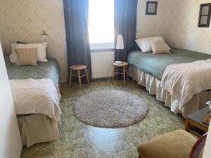 UndromThe Riverside的有两张床、一扇窗户和一张地毯的房间