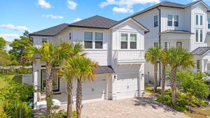 ein Haus mit Palmen davor in der Unterkunft Family-Friendly Coastal Escape Grill Decks More in Santa Rosa Beach