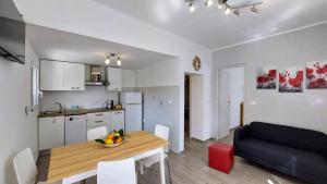 a kitchen and living room with a table and a couch at CÀ del SOLE in Borgio Verezzi