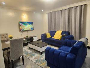 a living room with a blue couch and a table at Elysian Homes Nakuru in Nakuru