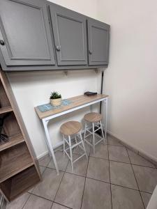 a small kitchen with a table and two stools at Le Cocon Fleuri in Auxerre +6 photos