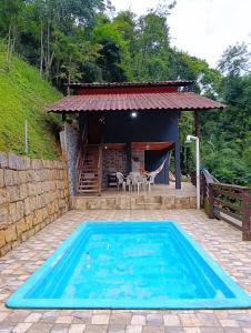 a swimming pool in front of a house at Chalé do Mato in Itatiaia