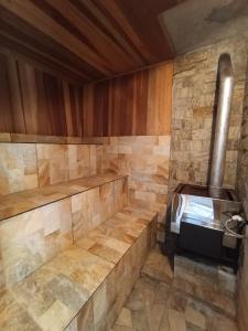a sauna with a woodburning stove in a room at Chalé do Mato in Itatiaia